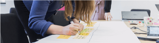 Image of a person writing notes on a Post-it note