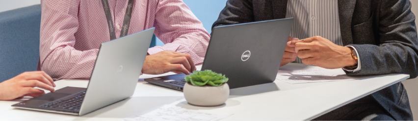 Picture of two colleagues at a desk on their laptop